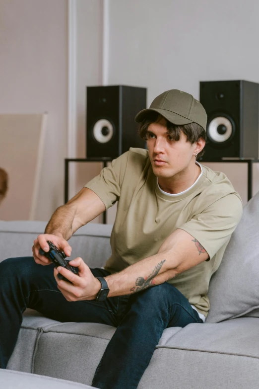 a man sitting on a couch playing a video game, inspired by John Luke, pexels contest winner, realism, wearing a baseball cap, orelsan, muted colors. ue 5, portrait shot
