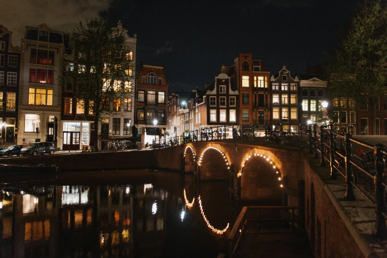 a bridge over a body of water at night, a photo, by Jan Tengnagel, pexels contest winner, renaissance, dutch houses along a river, profile image, night time footage, slightly tanned