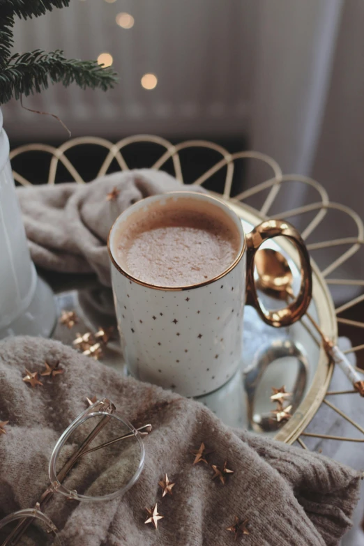 a cup of coffee sitting on top of a table, ivory and copper, winter, thumbnail, bubbly