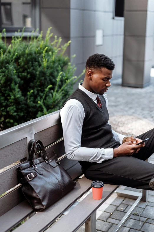 a man sitting on a bench using a laptop, trending on pexels, wearing a vest and a tie, man is with black skin, checking her phone, pinstripe suit