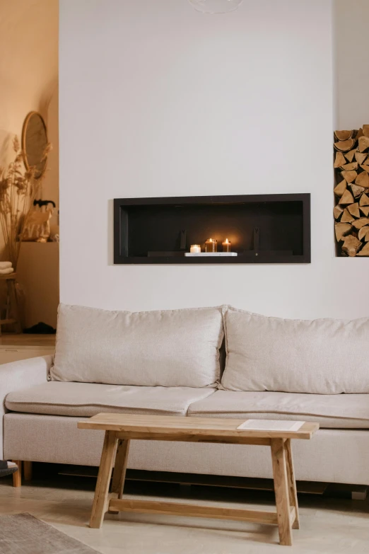 a living room filled with furniture and a fire place, inspired by Einar Hakonarson, trending on unsplash, minimalism, light beige pillows, simple wood shelves, candlelit, recessed