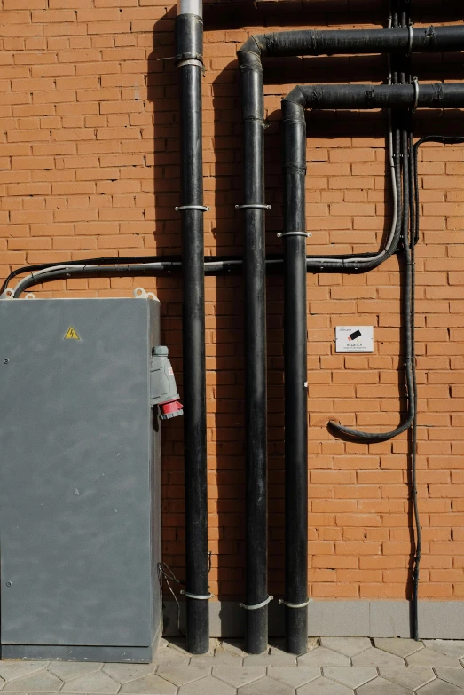 a couple of pipes that are on the side of a building, battery and wires, promo image, panel of black, rectangles
