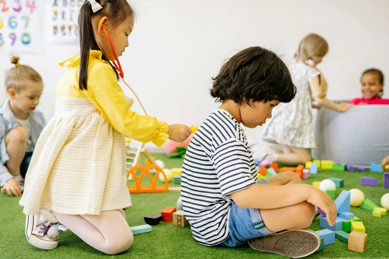 a group of children sitting on the ground playing with blocks, pexels contest winner, interactive art, two buddies sitting in a room, profile image, standing in class, te pae