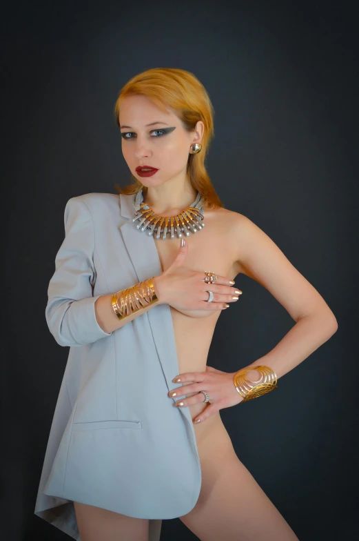 a woman in a blue dress posing for a picture, an album cover, trending on pexels, renaissance, wearing two silver bracelets, jacket over bare torso, olya bossak, egyptian