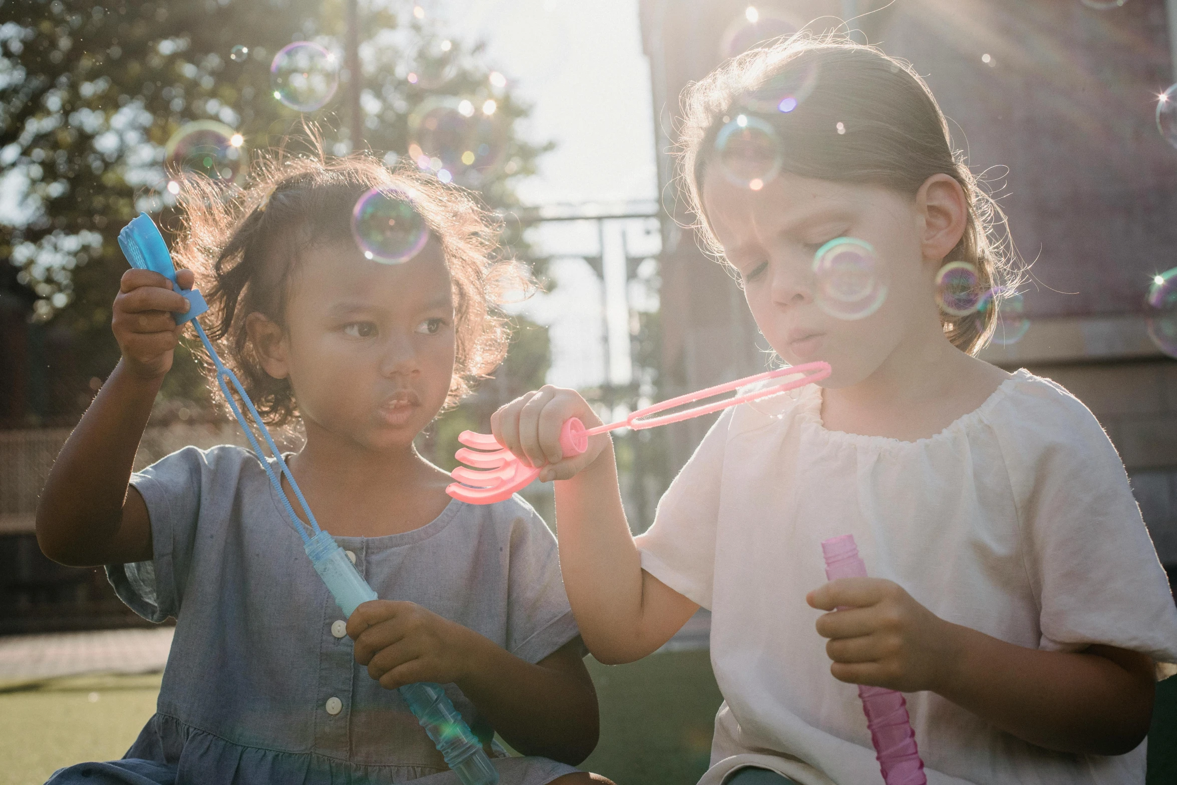 two little girls blowing bubbles on a sunny day, pexels contest winner, glow sticks, professionally post - processed, the clangers, portrait image