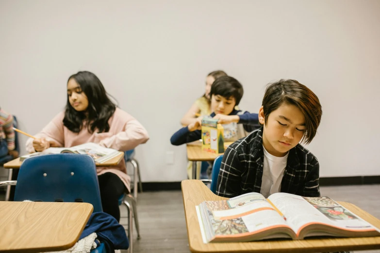 a group of children sitting at desks in a classroom, by Jang Seung-eop, pexels contest winner, vancouver school, trying to read, “hyper realistic, background image, looking serious