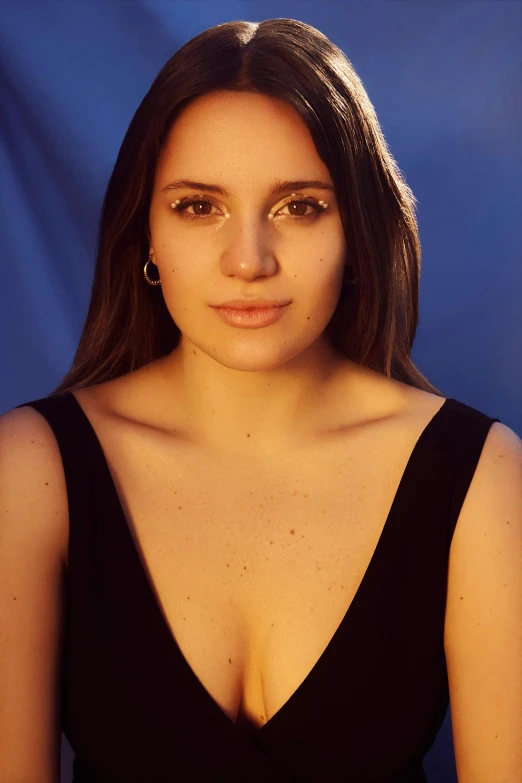 a woman in a black dress posing for a picture, inspired by Amelia Peláez, photorealism, face is brightly lit, photo from a promo shoot, solid background, she is wearing a black tank top