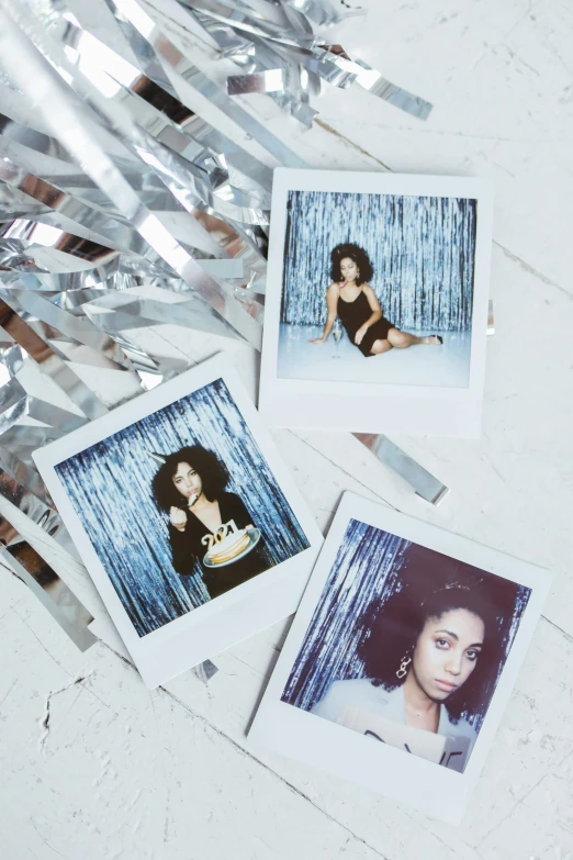 a bunch of polaroids sitting on top of a table, inspired by Nan Goldin, trending on pexels, holography, portrait of vanessa morgan, silver curly hair, glitter, sza