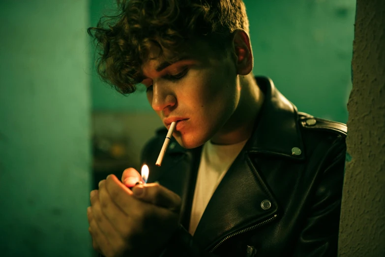 a man in a leather jacket lighting a cigarette, inspired by Nan Goldin, trending on pexels, teen boy, non binary model, ignant, candlelit