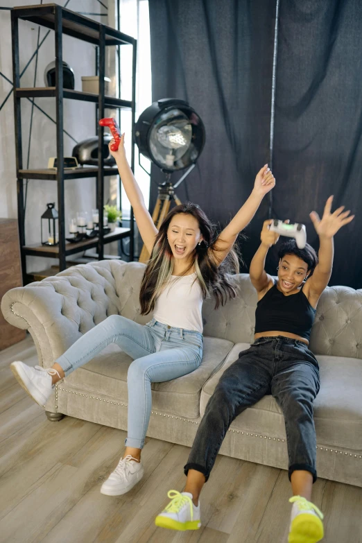 a couple of people that are sitting on a couch, hands in the air, game ready, kids playing, film studio