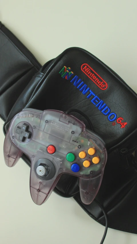 a bag with a game controller attached to it, inspired by Mario Cooper, unsplash, neogeo, translucent body, n 6 4, reuters, uses c4