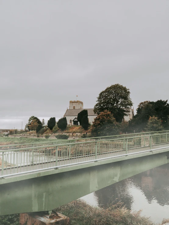 a bridge over a body of water with a castle in the background, by IAN SPRIGGS, unsplash, overcast gray skies, river stour in canterbury, hd footage, instagram story