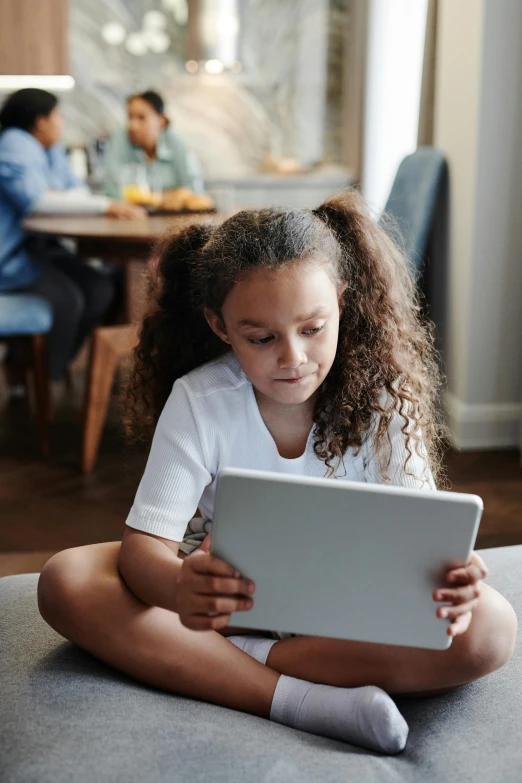 a little girl sitting on the floor using a laptop, pexels contest winner, incoherents, lawther sit at table playing dnd, an olive skinned, ios, next gen