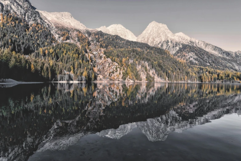 a body of water with mountains in the background, by Johannes Voss, pexels contest winner, metallic reflections, symmetrical image, late autumn, super clear detailed