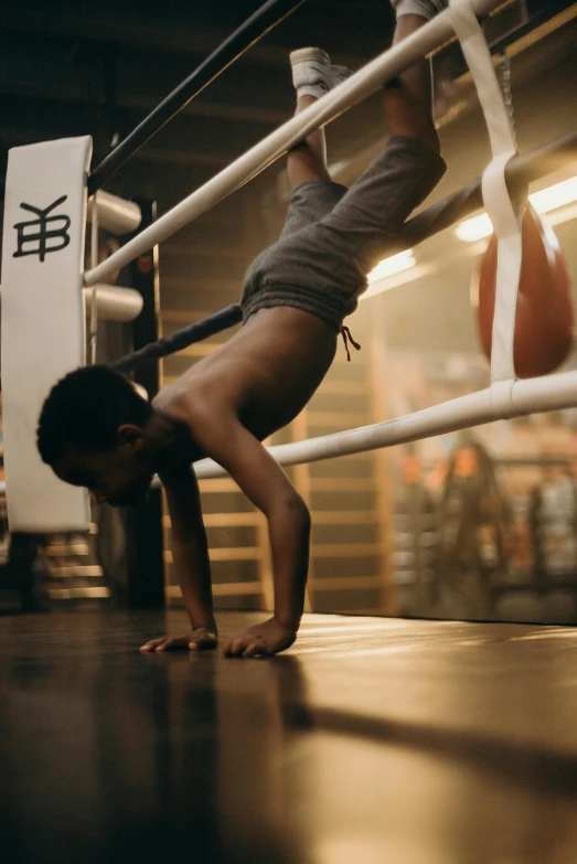 a man doing a handstand in a boxing ring, pexels contest winner, little kid, black teenage boy, square, working out