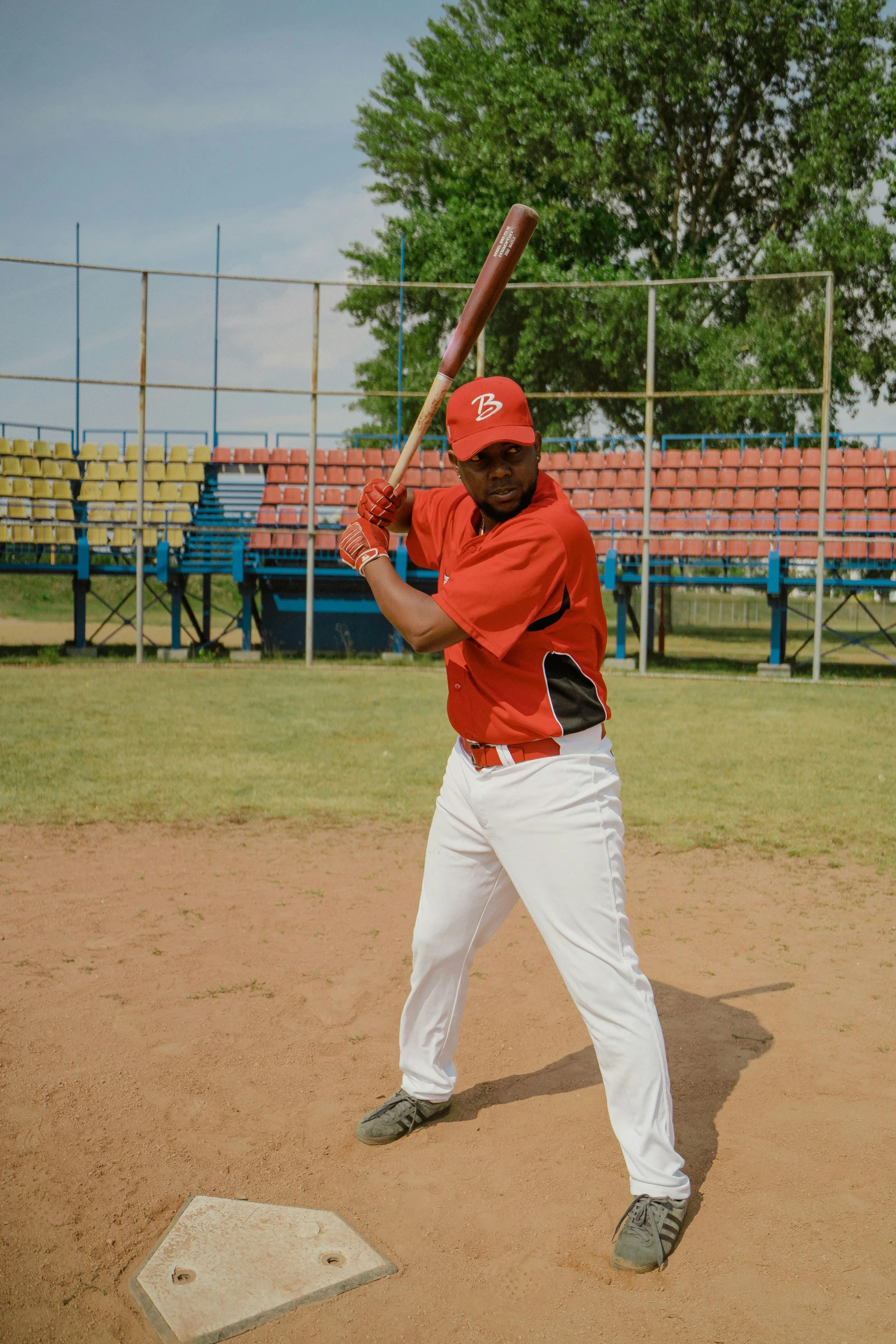 a man holding a baseball bat on top of a field, cuban setting, high-quality photo, power stance, pitch bending