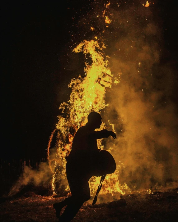 a man kneeling down in front of a fire, by Attila Meszlenyi, unsplash contest winner, conceptual art, profile image, pyrotechnics, fuming effigy, lgbtq