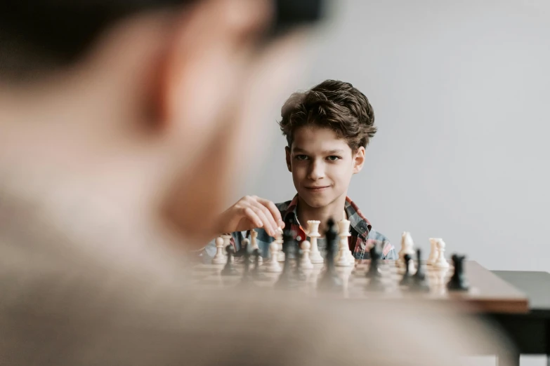 a young boy playing a game of chess, a picture, by Adam Marczyński, pexels contest winner, looking across the shoulder, photo of a model, lachlan bailey, fabry glenn