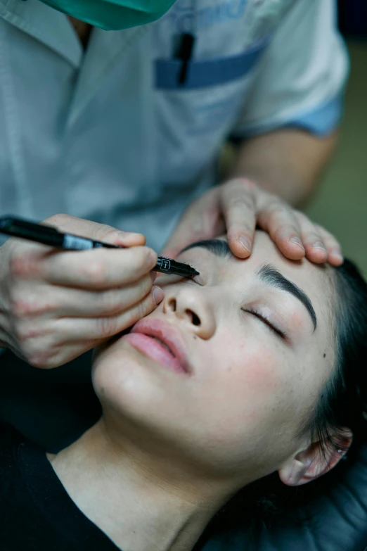 a woman getting her eyebrows done at a salon, by Adam Marczyński, asian human, centered shot, medium angle, wētā fx