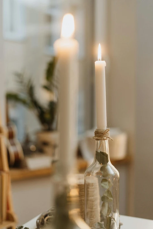a couple of candles sitting on top of a table, bottle, profile image, home display, white light