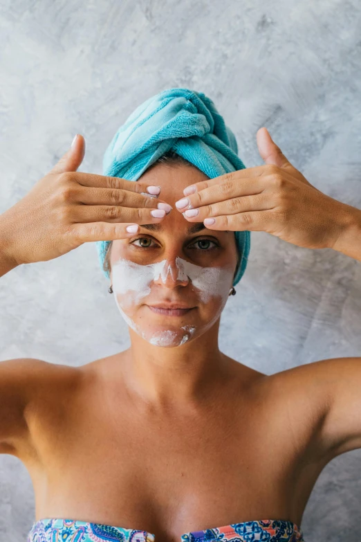 a woman with a towel wrapped around her head, trending on pexels, renaissance, silicone skin, hands shielding face, goggles on forehead, square