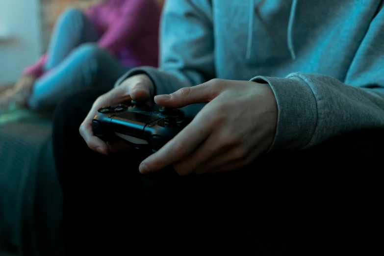 a close up of a person holding a video game controller, man sitting facing away, late evening, gaming room, instagram post