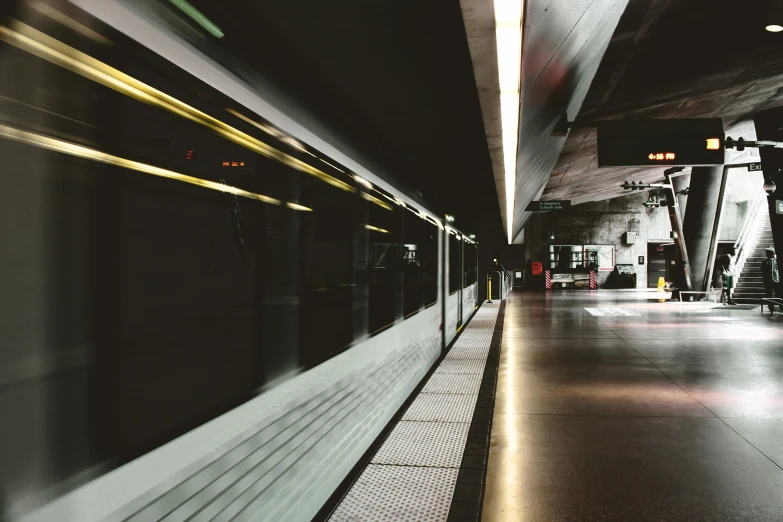 a train traveling down a train track next to a platform, unsplash, underground party, instagram picture, muted lights, 2000s photo