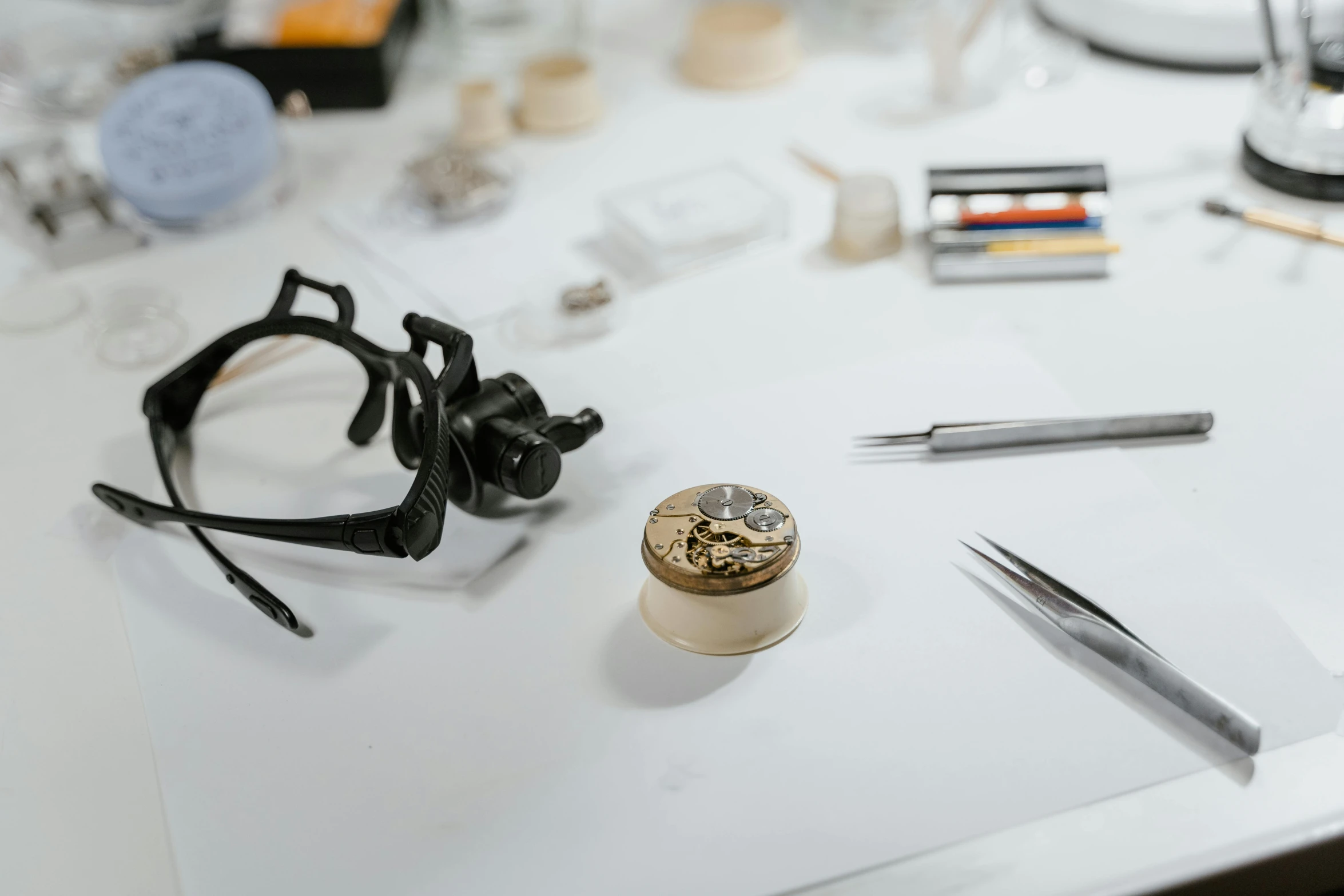 a pair of glasses sitting on top of a table, inspired by Frederik de Moucheron, arbeitsrat für kunst, lv jewelry, detailed product image, workbench, with small object details
