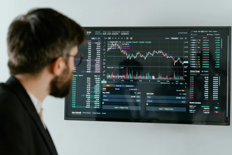 a man looking at a computer screen with graphs on it, by Adam Marczyński, trending on pexels, cryptocurrency, television show, looking from side, low quality photo