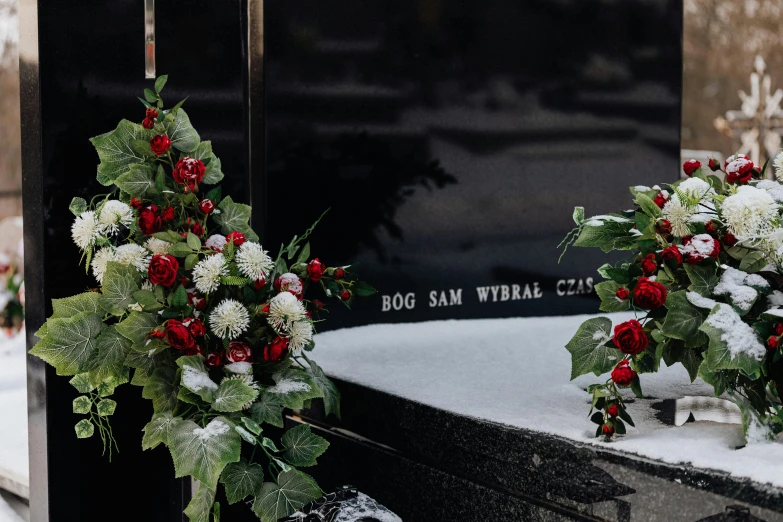 a couple of wreaths sitting on top of a grave, inspired by Mihály Munkácsy, unsplash, white and red roses, 3 - piece, etched inscriptions, frederik heyman