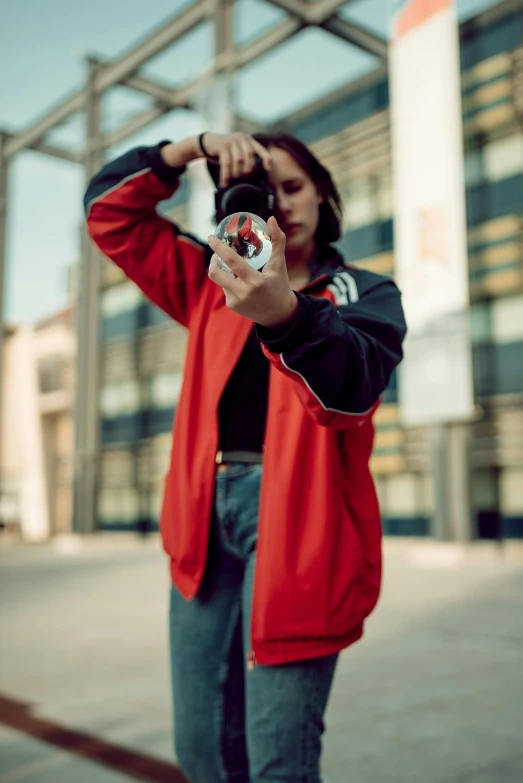 a woman taking a picture with a camera, a picture, by Adam Marczyński, pexels contest winner, graffiti, cool red jacket, chappie in an adidas track suit, holding a bottle, professional profile picture