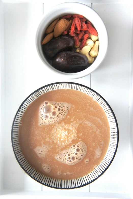 a close up of a bowl of food on a tray, inspired by Jacopo Bellini, hot cocoa drink, nut, view from bottom to top, moroccan