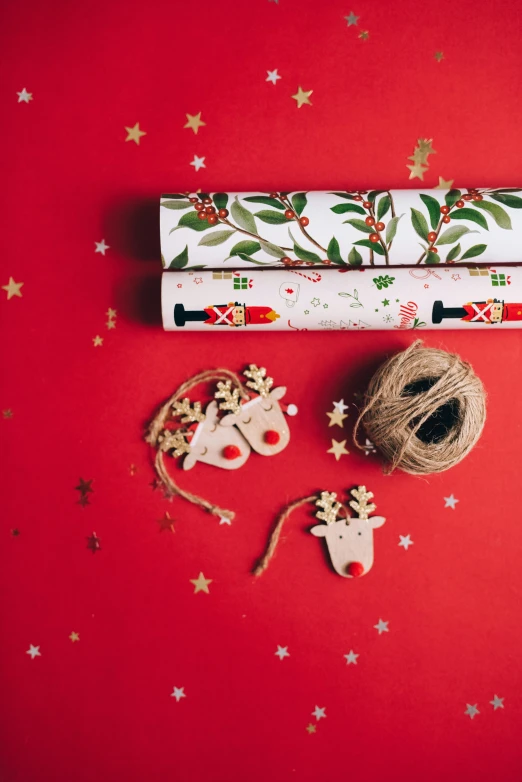 a roll of christmas wrapping next to a spool of twine of twine, by Julia Pishtar, high quality paper, teenager, red, toys