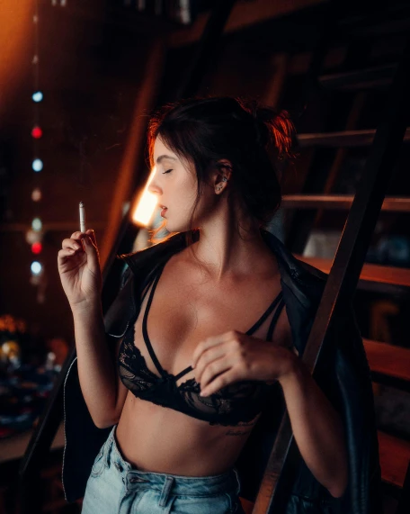 a woman smoking a cigarette in a dark room, a stock photo, inspired by Elsa Bleda, trending on pexels, posing together in bra, in a cabin, revealing outfit, instagram post