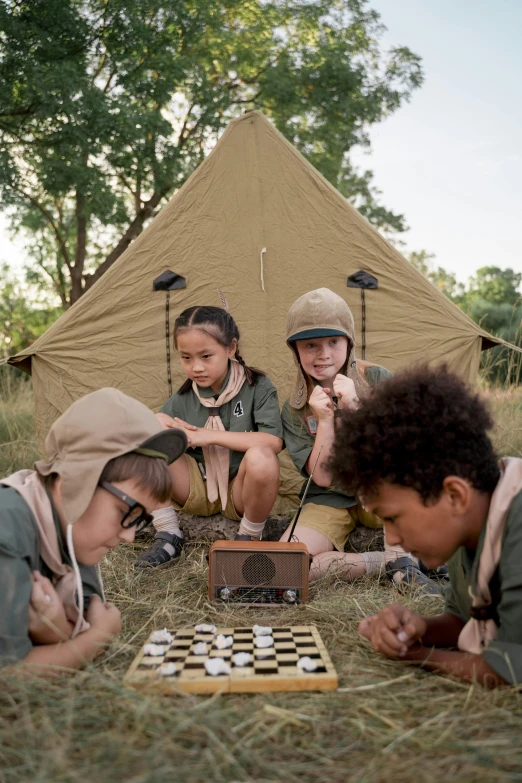 a group of children playing a game of checkers, inspired by Wes Anderson, wearing adventuring gear, tent, brown, safari