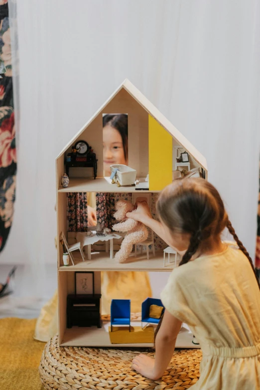 a little girl sitting on the floor playing with a doll house, by Julia Pishtar, pexels contest winner, modernism, stopmotion animation, standing, design your own avatar, closeup portrait