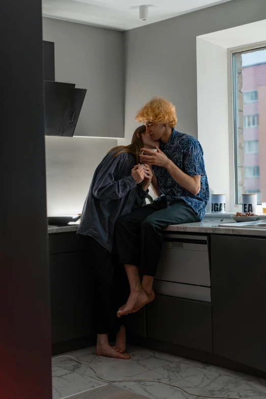 a couple of people sitting on top of a kitchen counter, a picture, by Elsa Bleda, trending on reddit, ginger hair with freckles, reylo kissing, low quality photo, bo burnham