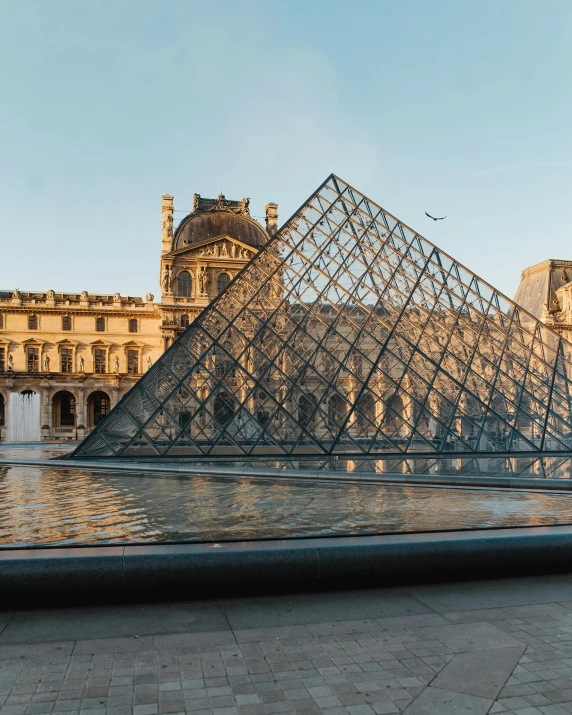 a large glass pyramid in front of a building, a marble sculpture, by Julia Pishtar, pexels contest winner, french, gif, lgbtq, tourist photo