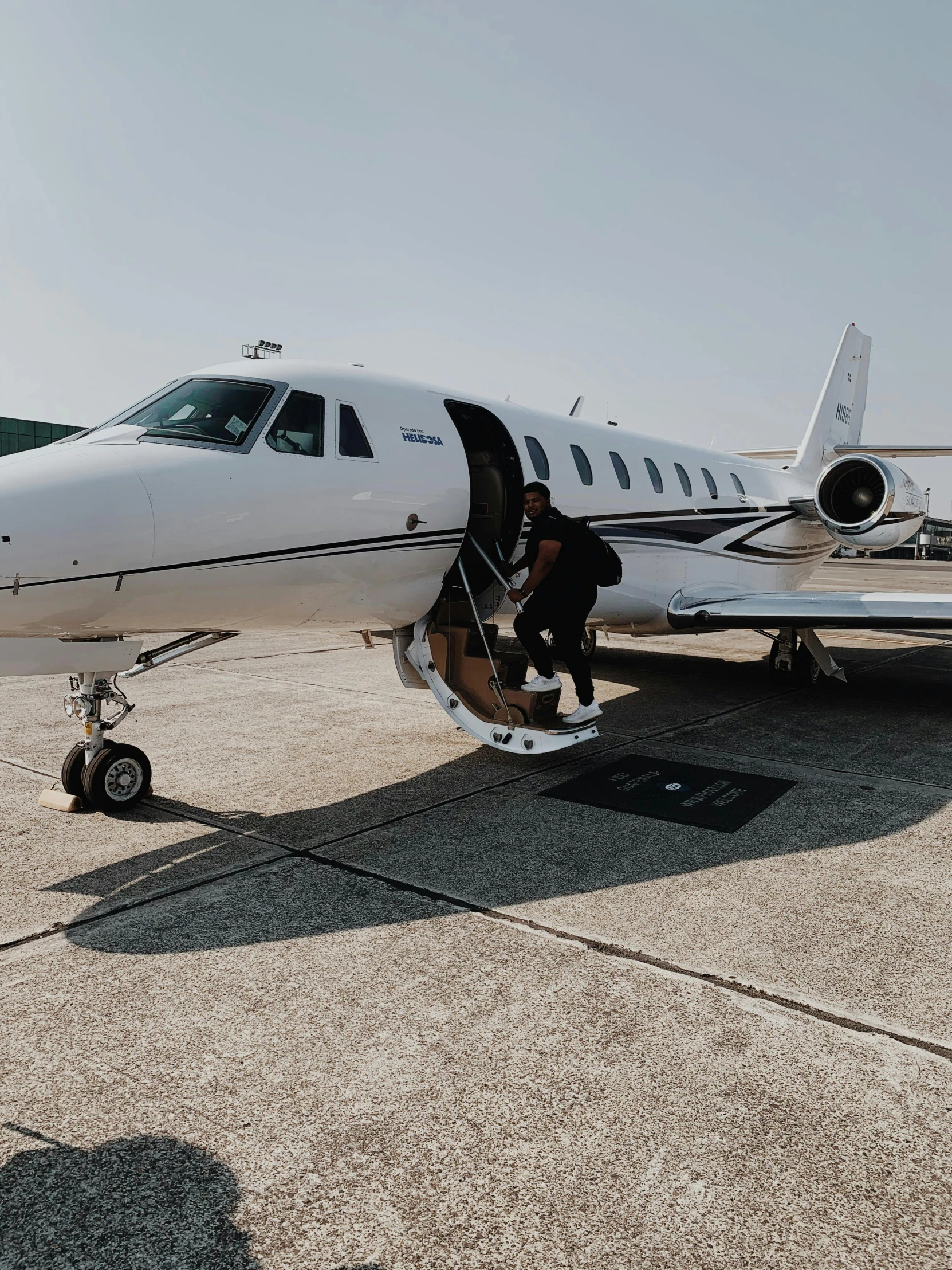 a small white jet sitting on top of an airport tarmac, an album cover, by Daniel Seghers, pexels contest winner, happening, high end interior, profile image, flaunting his wealth, mid body