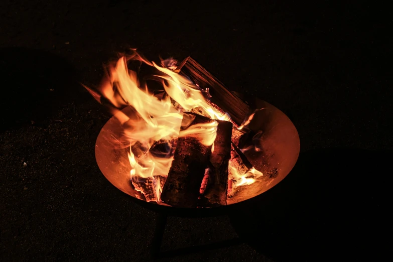 a close up of a fire in a metal bowl, soft outdoor light, complementary rim lights, mid night, woodfired