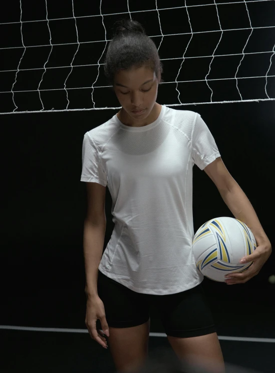 a woman holding a soccer ball in front of a net, inspired by Christen Dalsgaard, featured on dribble, short sleeves, compression, all white, indoor shot