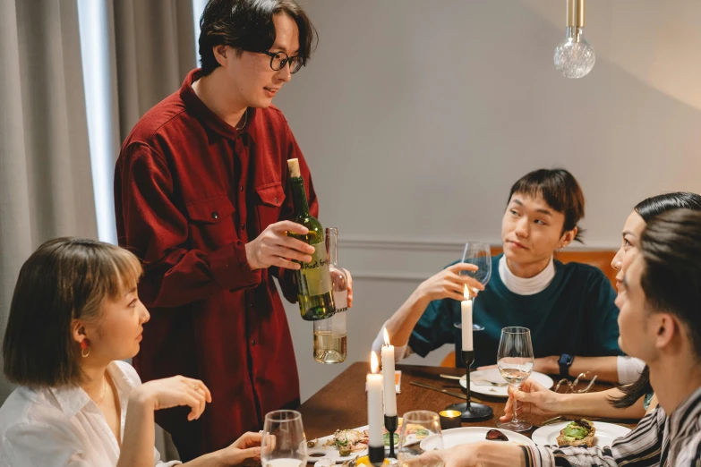 a group of people sitting around a dinner table, holding a bottle, cai xukun, thumbnail, hygge