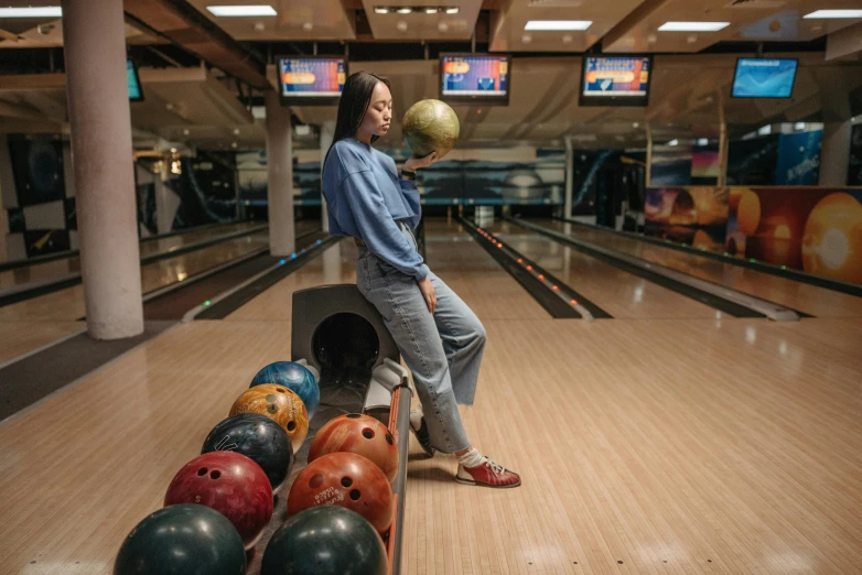 a woman holding a bowling ball in a bowling alley, a portrait, by Julia Pishtar, unsplash contest winner, darren quach, wide full body, instagram post, street life