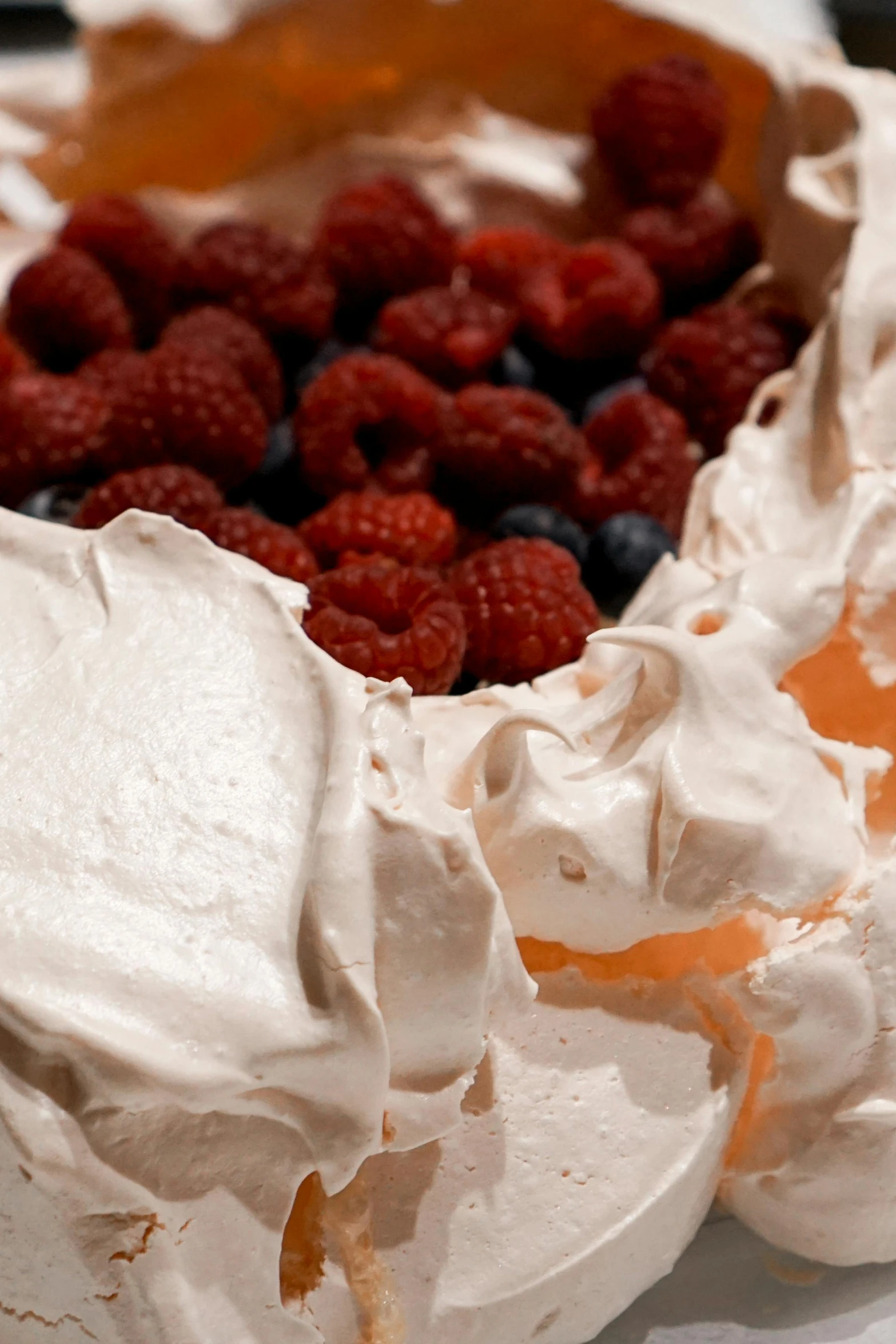 a white plate topped with a cake covered in frosting and raspberries, by David Simpson, pexels, figuration libre, intricate wrinkles, whirlpool, berries inside structure, marshmallow