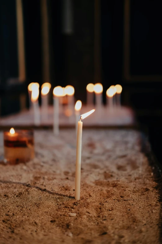 a group of candles sitting on top of a table, walking down, subtle detailing, torches in ground, soft light