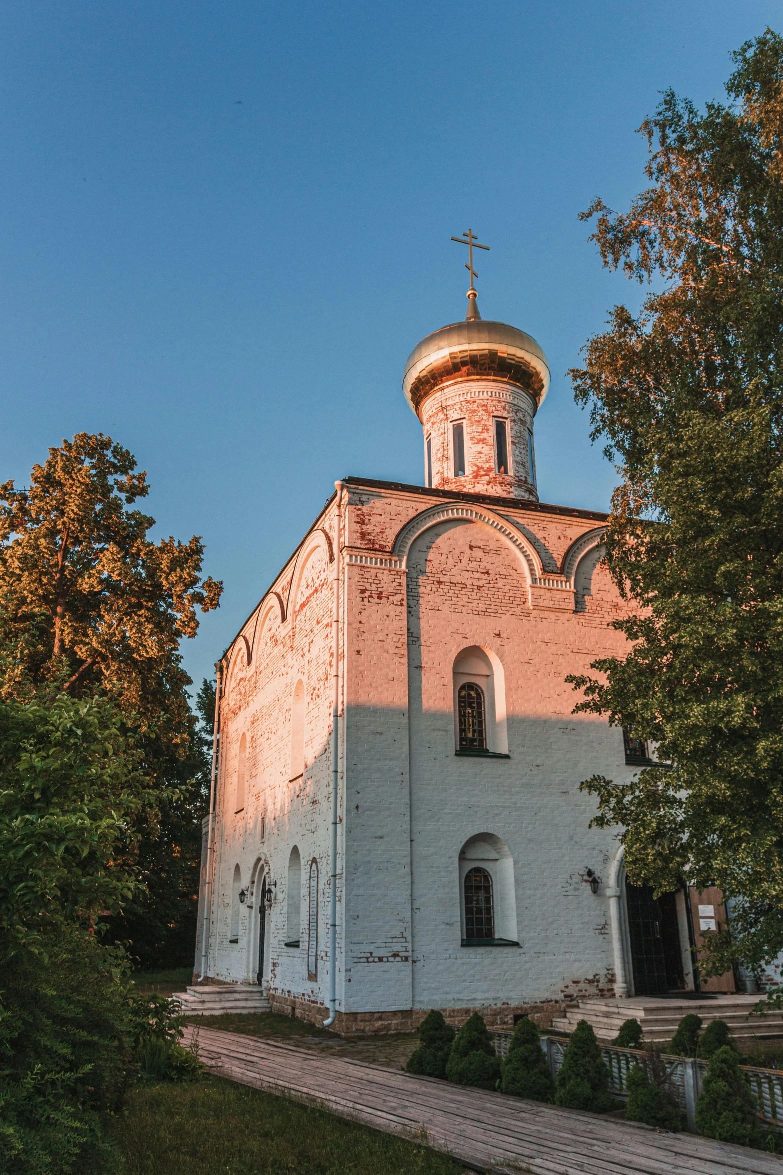 a large white building sitting on top of a lush green field, inspired by Illarion Pryanishnikov, unsplash contest winner, renaissance, in orthodox church, dappled in evening light, square, birch