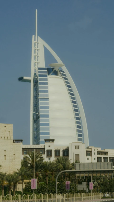 a very tall building in the middle of a city, dau-al-set, in style of norman foster, arab inspired, tail fin, -