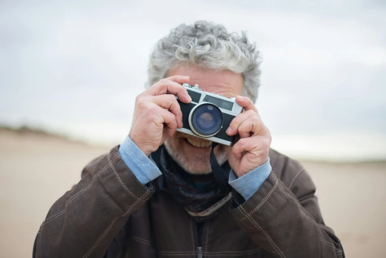a man taking a picture with a camera, by Peter Churcher, old gigachad with grey beard, hasselblad x 1 d sharp focus, casual photography, lightweight