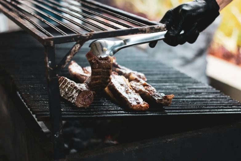 a close up of a person grilling meat on a grill, by Daniel Lieske, pexels contest winner, renaissance, “ iron bark, background image, ribs, grey