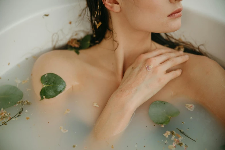 a woman that is sitting in a bath tub, inspired by Elsa Bleda, trending on pexels, renaissance, chest covered with palm leaves, lily pad, pale bluish skin, silicone skin